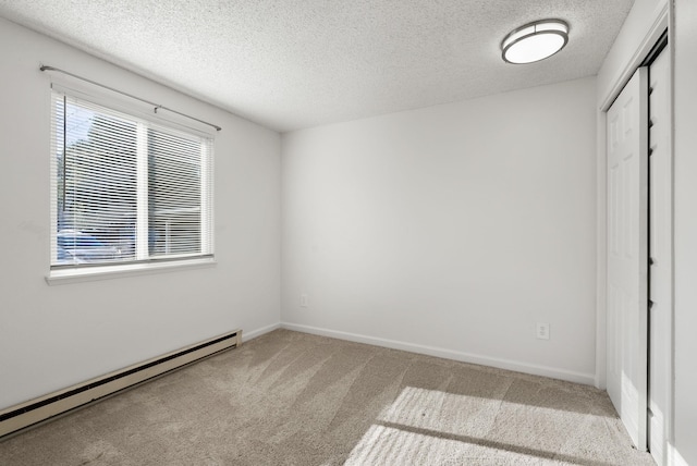 6125 N Addison St, Spokane, WA 99208 - unfurnished bedroom featuring a baseboard radiator, light colored carpet, a textured ceiling, and a closet