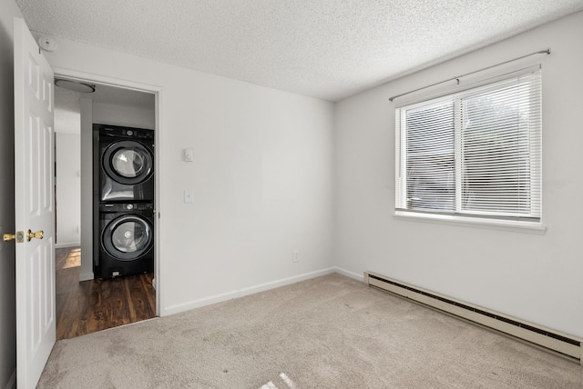 6125 N Addison St, Spokane, WA 99208 - empty room featuring a baseboard heating unit, stacked washing machine and dryer, carpet, and a textured ceiling