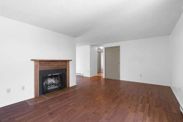 6125 N Addison St, Spokane, WA 99208 - unfurnished living room featuring wood finished floors, a fireplace with flush hearth, and a baseboard heating unit