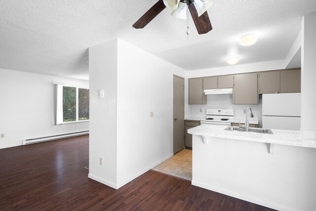6125 N Addison St, Spokane, WA 99208 - kitchen featuring baseboard heating, white appliances, under cabinet range hood, gray cabinets, and a breakfast bar