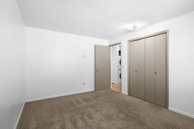 6125 N Addison St, Spokane, WA 99208 - unfurnished bedroom featuring carpet floors, a closet, a textured ceiling, and stacked washer and clothes dryer