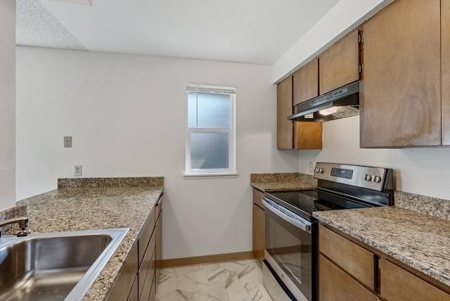6125 N Addison St, Spokane, WA 99208 - kitchen with stainless steel range with electric stovetop, under cabinet range hood, light marble finish floors, brown cabinets, and light countertops