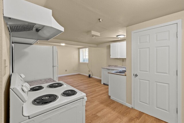903 S Adams St, Spokane, WA 99204 - kitchen with white appliances, exhaust hood, light wood finished floors, white cabinetry, and light countertops
