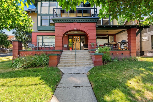 903 S Adams St, Spokane, WA 99204 - view of front of home featuring brick siding, a front lawn, covered porch, a balcony, and stucco siding
