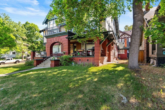 903 S Adams St, Spokane, WA 99204 - view of front of house featuring brick siding, a balcony, a front yard, and a porch