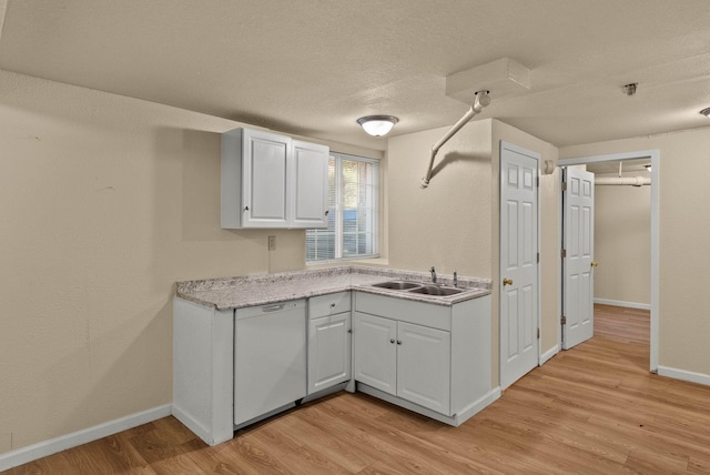 903 S Adams St, Spokane, WA 99204 - kitchen with dishwasher, light wood finished floors, light countertops, white cabinetry, and a textured ceiling