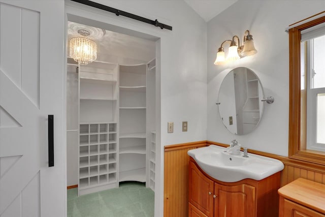 8722 E Boardwalk Ln, Spokane, WA 99212 - bathroom with vanity, a chandelier, wainscoting, vaulted ceiling, and a spacious closet