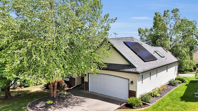 8722 E Boardwalk Ln, Spokane, WA 99212 - view of front facade featuring concrete driveway, a shingled roof, a front yard, roof mounted solar panels, and a garage