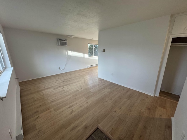 824-830 E N Ave, Spokane, WA 99207 - interior space with wood finished floors, a wall mounted air conditioner, and a baseboard radiator