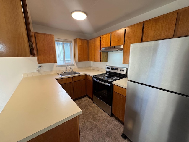 824-830 E N Ave, Spokane, WA 99207 - kitchen with stainless steel appliances, under cabinet range hood, brown cabinetry, and light countertops