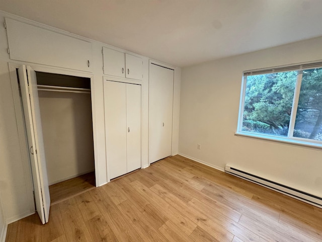 824-830 E N Ave, Spokane, WA 99207 - unfurnished bedroom featuring multiple closets, a baseboard radiator, and light wood-style floors
