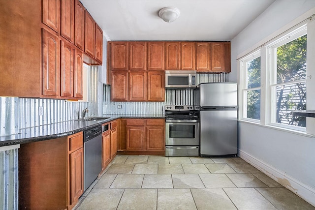 1304 W 15th Ave, Spokane, WA 99203 - kitchen featuring stainless steel appliances, brown cabinetry, dark stone counters, and backsplash