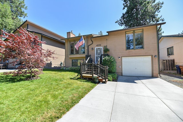 4232 E 10th Ave, Spokane, WA 99202 - split foyer home featuring an attached garage, driveway, and a chimney