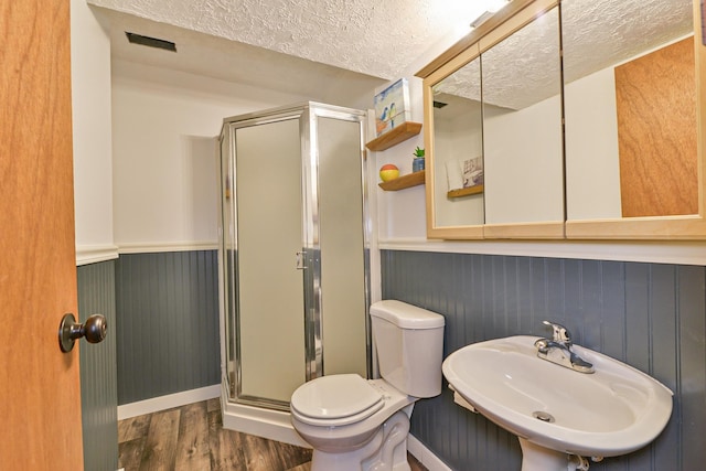 4232 E 10th Ave, Spokane, WA 99202 - bathroom with a textured ceiling, wood finished floors, a shower stall, and wainscoting