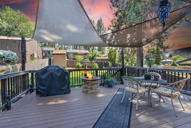4232 E 10th Ave, Spokane, WA 99202 - wooden terrace with an outdoor fire pit, outdoor dining area, grilling area, and a storage shed