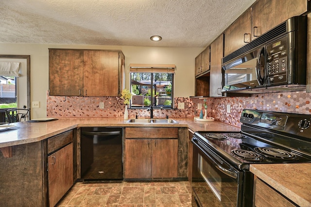 4232 E 10th Ave, Spokane, WA 99202 - kitchen with black appliances, a peninsula, plenty of natural light, light countertops, and a textured ceiling