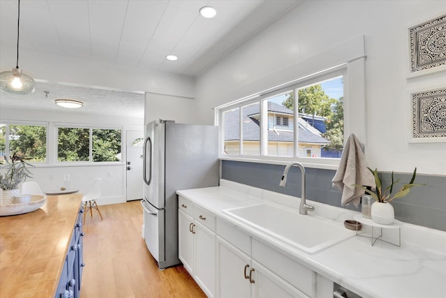 2116 N Jefferson St, Spokane, WA 99205 - kitchen featuring freestanding refrigerator, healthy amount of natural light, white cabinetry, light wood finished floors, and recessed lighting