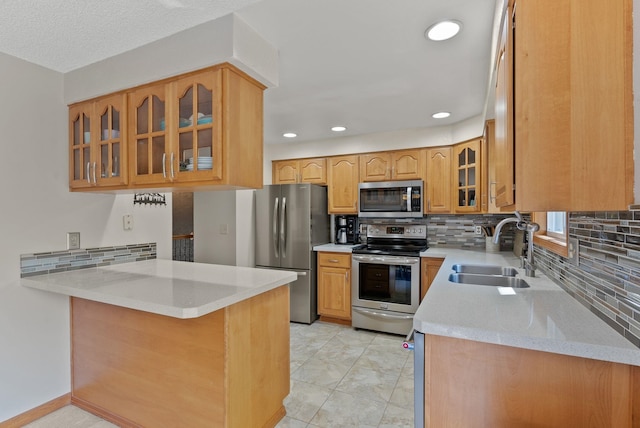 11919 S Player Dr, Spokane, WA 99223 - kitchen with appliances with stainless steel finishes, backsplash, glass insert cabinets, a peninsula, and recessed lighting