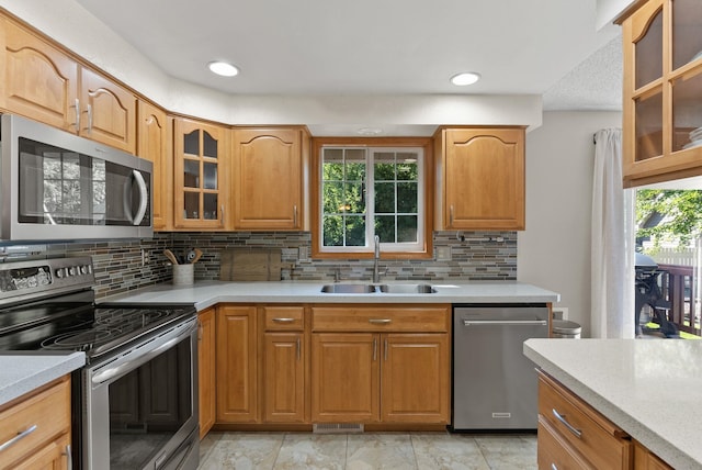 11919 S Player Dr, Spokane, WA 99223 - kitchen with stainless steel appliances, light countertops, glass insert cabinets, and decorative backsplash
