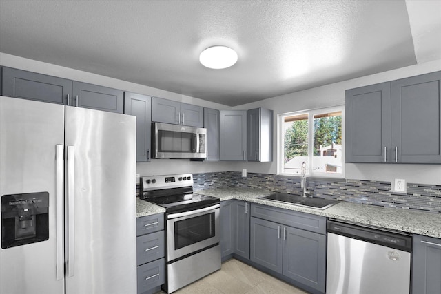 10109 E 9th Ave, Spokane Valley, WA 99206 - kitchen with appliances with stainless steel finishes, gray cabinets, light stone countertops, and a textured ceiling