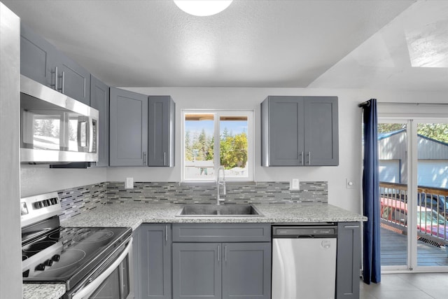 10109 E 9th Ave, Spokane Valley, WA 99206 - kitchen with stainless steel appliances, gray cabinets, and decorative backsplash