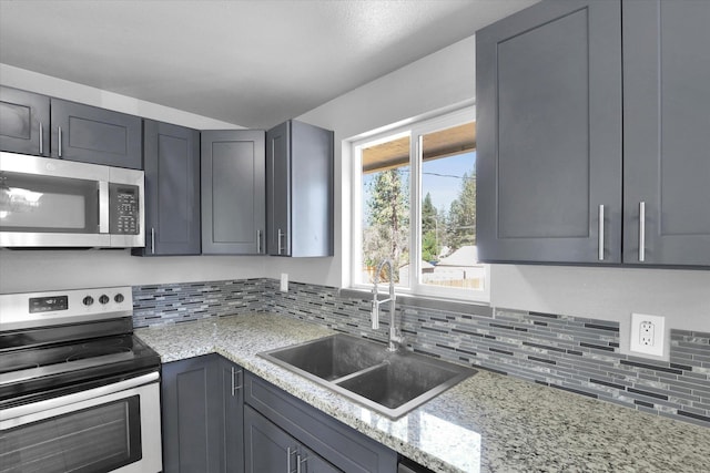 10109 E 9th Ave, Spokane Valley, WA 99206 - kitchen featuring appliances with stainless steel finishes, decorative backsplash, gray cabinets, and light stone counters