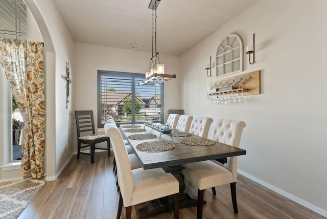1115 S Mcmillan Rd, Spokane Valley, WA 99016 - dining space with wood finished floors, arched walkways, and a chandelier