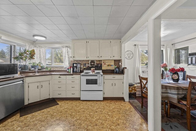 7225 E 11th Ave, Spokane, WA 99212 - kitchen with stainless steel appliances, dark countertops, white cabinets, and light floors