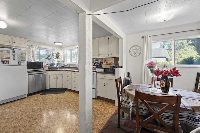 7225 E 11th Ave, Spokane, WA 99212 - kitchen with white appliances, dark countertops, a paneled ceiling, light floors, and white cabinets