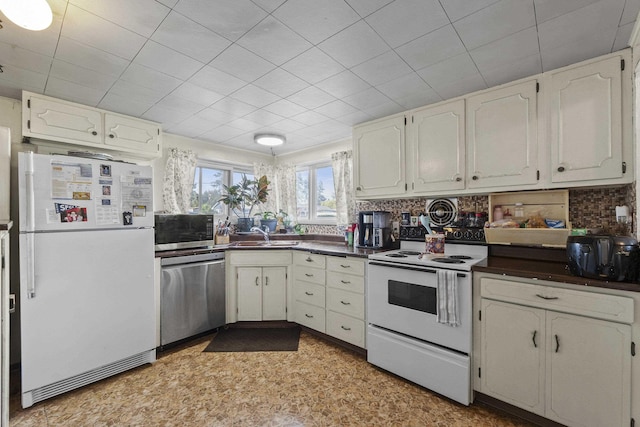 7225 E 11th Ave, Spokane, WA 99212 - kitchen with appliances with stainless steel finishes, dark countertops, backsplash, and white cabinets