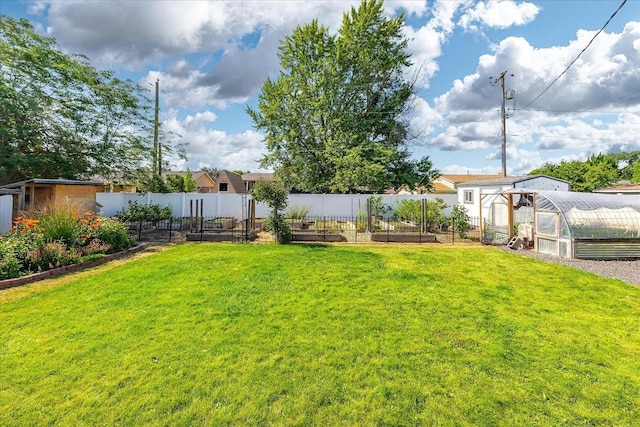 14020 S Sharp Ave, Spokane Valley, WA 99216 - view of yard featuring a greenhouse, a vegetable garden, and an outdoor structure