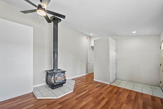 9801 Lakeshore Dr, Sagle, ID 83860 - unfurnished living room with a wood stove, wood finished floors, ceiling fan, and recessed lighting