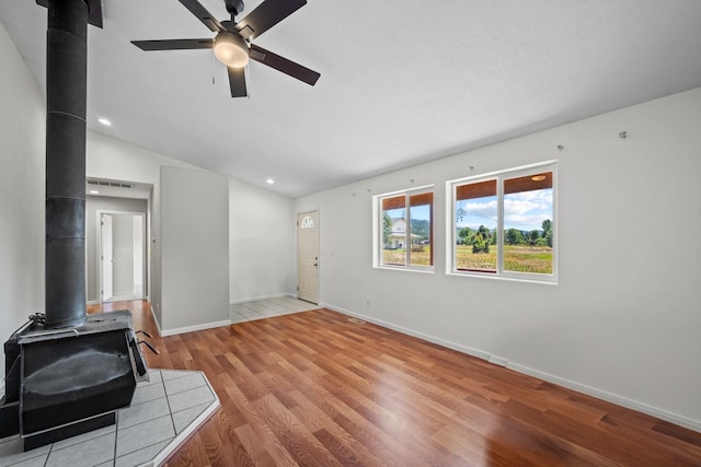9801 Lakeshore Dr, Sagle, ID 83860 - unfurnished living room featuring a wood stove, a ceiling fan, light wood-type flooring, vaulted ceiling, and recessed lighting