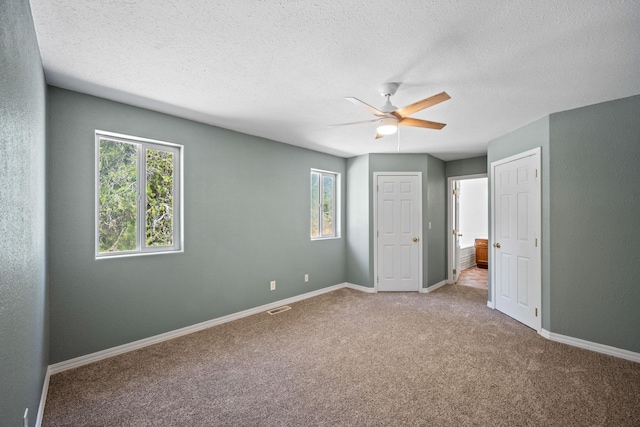 9801 Lakeshore Dr, Sagle, ID 83860 - unfurnished bedroom featuring carpet floors, a textured ceiling, ceiling fan, and ensuite bathroom