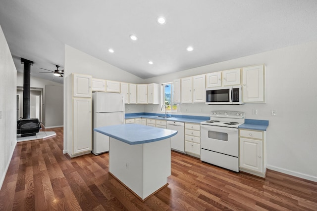 9801 Lakeshore Dr, Sagle, ID 83860 - kitchen featuring white appliances, vaulted ceiling, a center island, wood finished floors, and a wood stove
