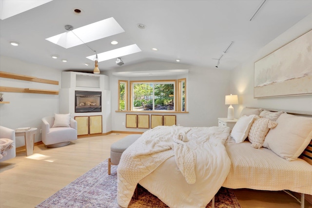 2714 E 11th Ave, Spokane, WA 99202 - bedroom with vaulted ceiling, a skylight, wood finished floors, recessed lighting, and a glass covered fireplace