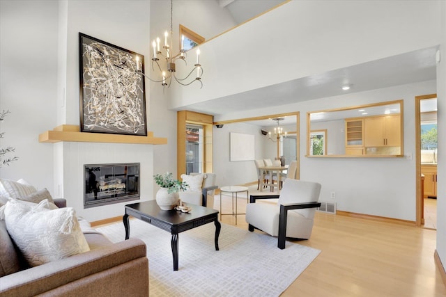 2714 E 11th Ave, Spokane, WA 99202 - living room featuring a chandelier, wood finished floors, a glass covered fireplace, and a high ceiling