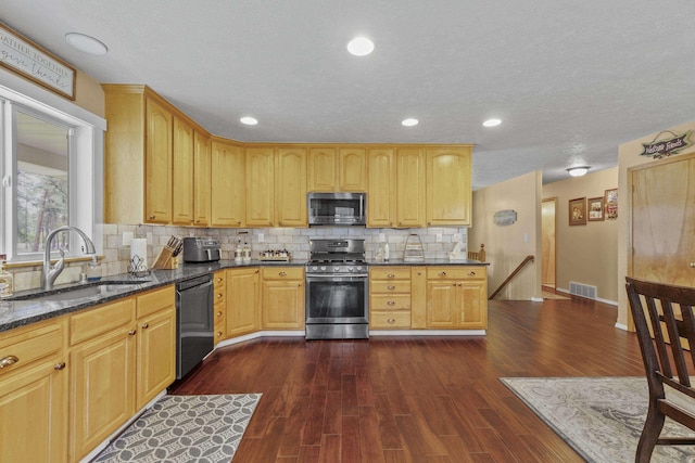 7905 W Seven Mile Rd, Nine Mile Falls, WA 99026 - kitchen featuring stainless steel appliances, dark stone countertops, dark wood-type flooring, tasteful backsplash, and recessed lighting