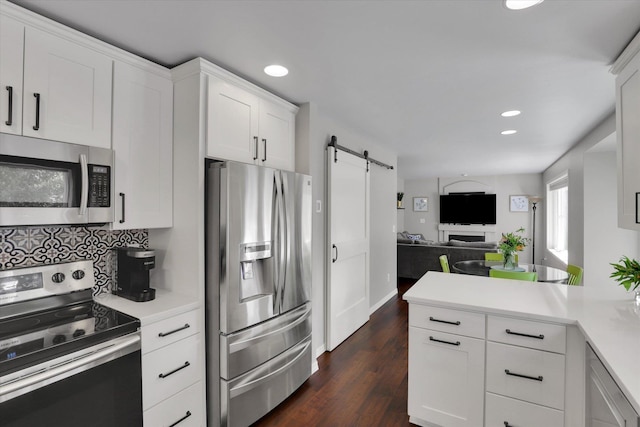 4116 S S Tenfel Ln, Spokane, WA 99223 - kitchen with appliances with stainless steel finishes, a barn door, open floor plan, light countertops, and white cabinetry