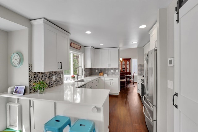 4116 S S Tenfel Ln, Spokane, WA 99223 - kitchen with freestanding refrigerator, a peninsula, recessed lighting, decorative backsplash, and light countertops
