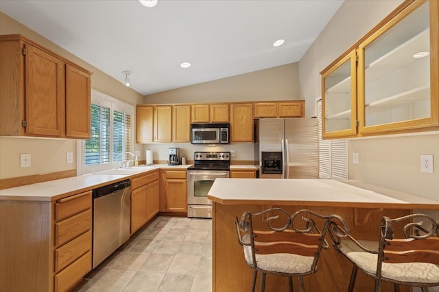 4211 S Greystone Ln Unit 4211, Spokane, WA 99223 - kitchen with stainless steel appliances, a peninsula, vaulted ceiling, glass insert cabinets, and light countertops