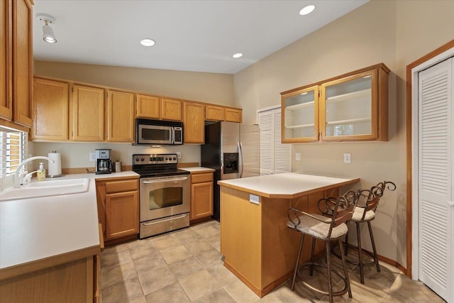 4211 S Greystone Ln Unit 4211, Spokane, WA 99223 - kitchen with appliances with stainless steel finishes, a peninsula, glass insert cabinets, light countertops, and vaulted ceiling