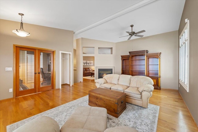 4211 S Greystone Ln Unit 4211, Spokane, WA 99223 - living room featuring lofted ceiling, french doors, wood finished floors, a ceiling fan, and a glass covered fireplace