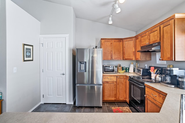 1636 E Vanetta Ln, Spokane, WA 99217 - kitchen featuring appliances with stainless steel finishes, under cabinet range hood, dark tile patterned flooring, lofted ceiling, and brown cabinets