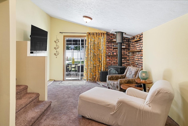 5003 N Normandie St, Spokane, WA 99205 - living area featuring vaulted ceiling, carpet flooring, a wood stove, and a textured ceiling