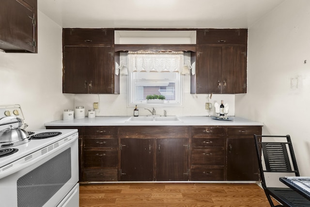5218 E Commerce Ave, Spokane, WA 99212 - kitchen with electric stove, light wood finished floors, dark brown cabinets, and light countertops
