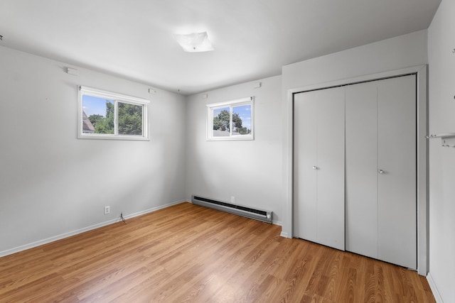 5218 E Commerce Ave, Spokane, WA 99212 - unfurnished bedroom with baseboard heating, light wood finished floors, and a closet