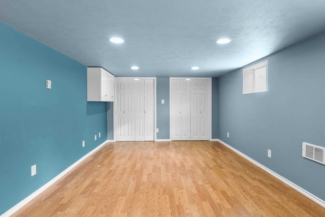 5218 E Commerce Ave, Spokane, WA 99212 - unfurnished bedroom with multiple closets, light wood finished floors, recessed lighting, and a textured ceiling