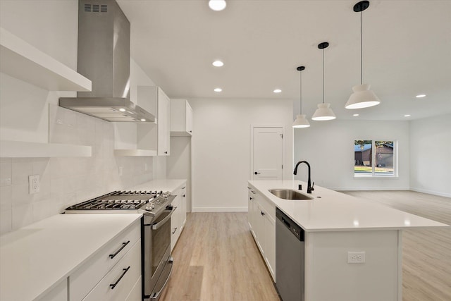 6203 E 13th Ln, Spokane Valley, WA 99212 - kitchen featuring wall chimney range hood, stainless steel appliances, light wood finished floors, decorative backsplash, and white cabinetry