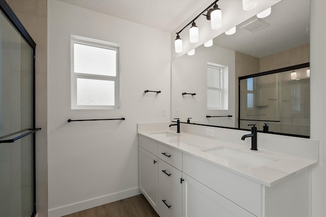 6203 E 13th Ln, Spokane Valley, WA 99212 - bathroom featuring double vanity, wood finished floors, and a shower with shower door
